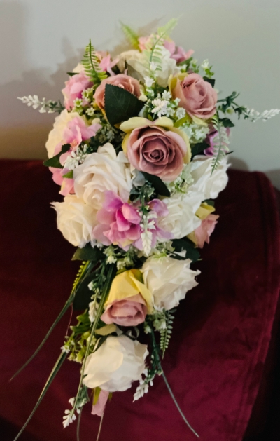 A faux flower  shower bouquet in pink shades , top quality silk flowers are used with a selection of silk green foliage