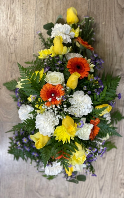 sympathy  arrangement in fresh flower with a mixed colour selection in seasonal flowers