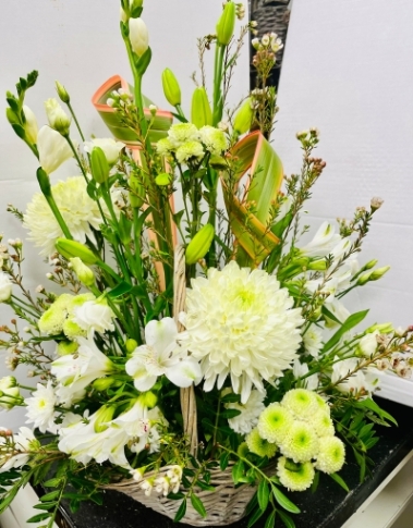 A basket of flowers with a great selection of ivory flowers and great hint of green and a selection of pale green flowers