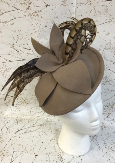 A beige colour fascinator enhanced with some striking feathers a really beautiful piece