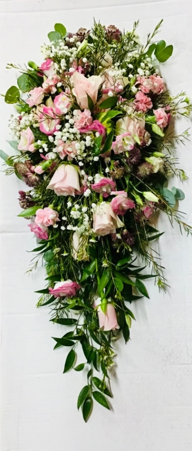 A long shower bouquet with roses in pink and a selection of small summer flowers and foliages