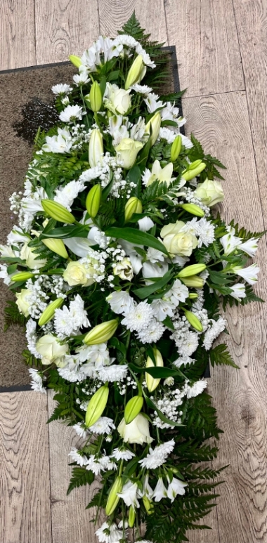 A very large funeral tribute is 5ft long, a design with lilies and roses and complimentary white flowers and green foliage