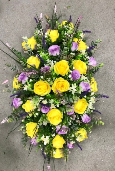 Faux flower memory tribute with yellow silk roses and a selection of foliage and grasses, design is weighted for stability