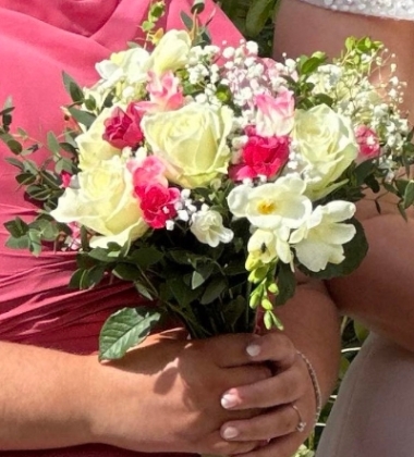 Fresh flower wedding posy style bouquet created with cerise pink and white rose and white freesia , some foliage